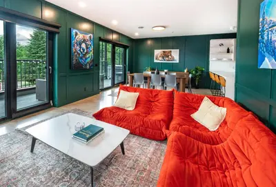 a living room with a red couch and a table at Revelstoke Mountain Penthouse in Revelstoke