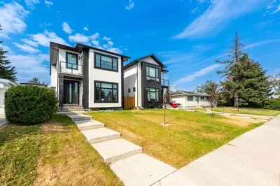 a black and white house with a yard at Newly built 2 bedroom suite with kitchen & laundry in Calgary