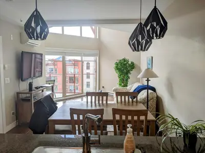 a kitchen and living room with a table and chairs at Copper Sky Paradise in West Kelowna