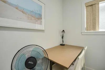 a room with a table and a fan next to a desk at Spacious Family Home in Vancouver in Vancouver