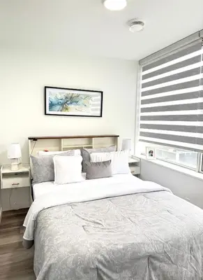 a bedroom with a large bed and a window at Cozy 1-Bedroom with Downtown City views in Edmonton