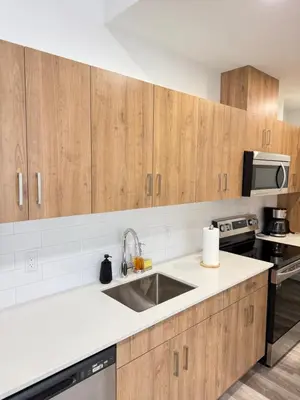 a kitchen with wooden cabinets and a sink at Cozy 1-Bedroom with Downtown City views in Edmonton