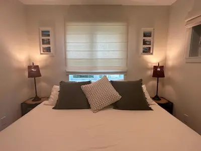 a bedroom with a bed with two lamps and a window at Studio Cedar Guest Cottage in Duncan