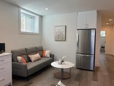 a living room with a couch and a refrigerator at Relaxing 2BR Stay - Kitchen & Central Convenience in Vancouver