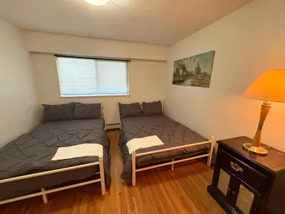 a bedroom with two beds and a bed and a table at Vancouver Home - Downtown 15 Min, Transit Access - Free Parking & Wi-Fi in Vancouver