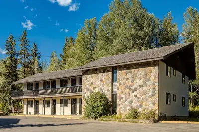 a stone building with a gambrel roof at Gateway Suites Rocky Mountains stay near Banff in Canmore