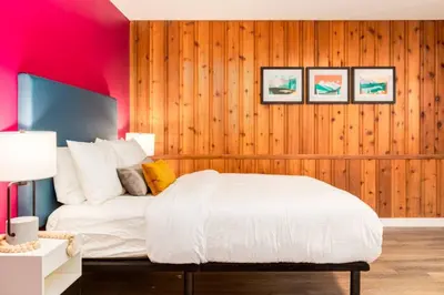 a bedroom with a white bed and pink walls at Gateway Suites Perfect rest on your way to Banff in Canmore