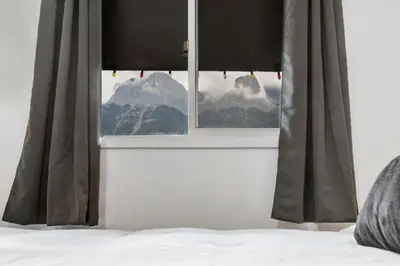 a bedroom window with a view of a mountain at Gateway Suites Charming Stay perfect for 4 Guests in Canmore