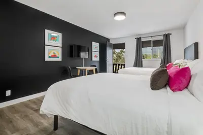a bedroom with a large white bed with pink pillows at Gateway Suites Charming Stay perfect for 4 Guests in Canmore