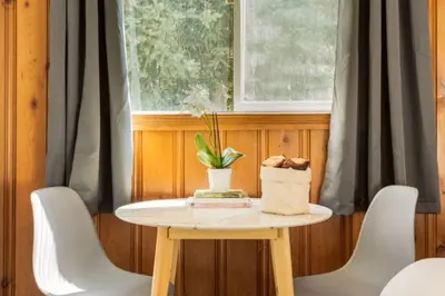 a small table with white chairs and a window at Gateway Suites near Banff in Canmore