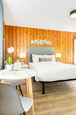 a bedroom with a large bed and two tables and chairs at Gateway Suites near Banff in Canmore