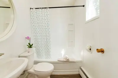 a white bathroom with a toilet and a sink at Gateway Suites near Banff in Canmore