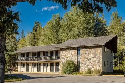 an old stone building with a gambrel roof at Gateway Suites Perfect Escape to explore Banff in Canmore