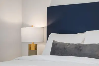 a bedroom with a white bed with a blue headboard at Gateway Suites Perfect Escape to explore Banff in Canmore