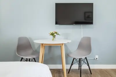 a table with two chairs and a tv on a wall at Gateway Suites Lovely views near Banff in Canmore