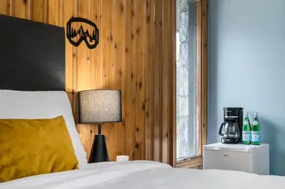 a bedroom with a bed and a lamp on a night stand at Gateway Suites Cozy stay to explore Banff and Canmore in Canmore