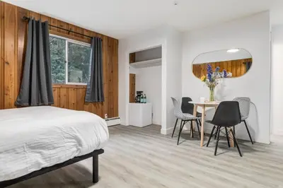 a bedroom with a bed and a table and chairs at Gateway Suites Near Canmore and Banff in Canmore