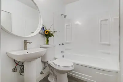 a bathroom with a toilet and a sink and a mirror at Gateway Suites Near Canmore and Banff in Canmore