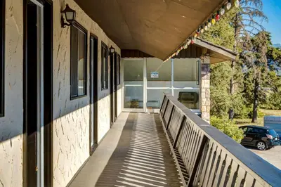 a walkway leading to a building with a car at Gateway Suites Cozy Getaway Near Banff and Canmore in Canmore