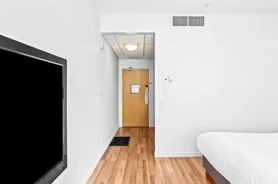 a bedroom with a bed and a flat screen tv at Mini Getaway with Mountain Views Near Banff in Canmore