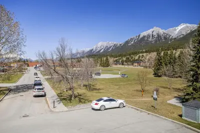 a white car parked in a parking lot with mountains in the background at Mini Getaway with Mountain Views Near Banff in Canmore