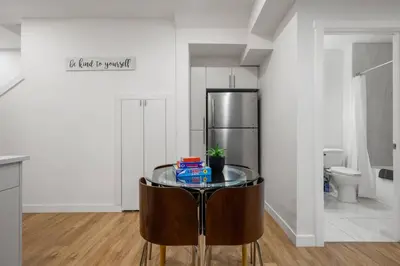 a kitchen with a glass table and a refrigerator at Modern 2BR Private Suite Near Calgary Airport in Calgary