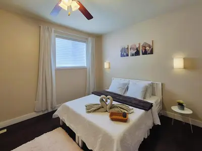 a bedroom with a bed with two swans on it at Central 3 Bedroom Gem Near ICE District - Stadium and Malls in Edmonton