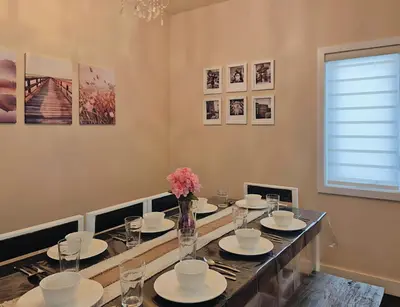 a dining room with a long table with plates and flowers at Central 3 Bedroom Gem Near ICE District - Stadium and Malls in Edmonton