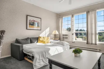 a room with two beds and a couch and a table at The Pinnacle in Fairmont 1BR Condo Near Hot Springs in Fairmont Hot Springs