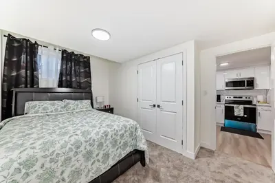 a bedroom with a bed and a kitchen at KimzNest in Edmonton