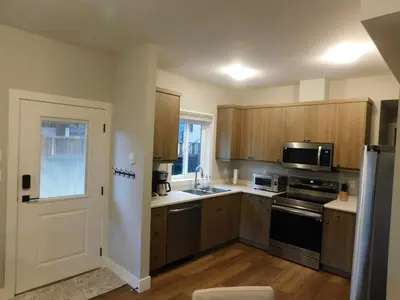 a kitchen with wooden cabinets and a sink and a refrigerator at Lakeview Escape in Northshore Estates in Lake Cowichan