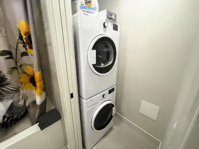 a washer and dryer in a corner of a room at Black Bears Den, Heated Pool, Hot Tub, Brand NEW! in Canmore