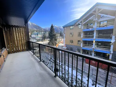 a balcony with a view of a building at Black Bears Den, Heated Pool, Hot Tub, Brand NEW! in Canmore