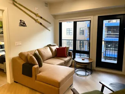 a living room with a couch and a table at Black Bears Den, Heated Pool, Hot Tub, Brand NEW! in Canmore