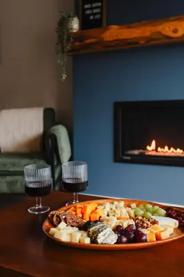 a plate of food on a table with two wine glasses at The Après Arcade in Sun Peaks