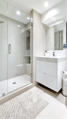 a white bathroom with a shower and a sink at Modern Private Suite with Parking - Cambie Village VGH in Vancouver