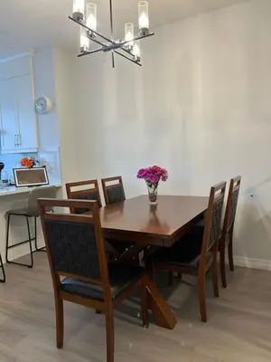 a dining room table with chairs and a vase of flowers at Sunny Queen-size Bedroom with Private Bath in Brand New House in Calgary
