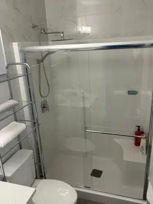 a bathroom with a glass shower with a toilet at Sunny Queen-size Bedroom with Private Bath in Brand New House in Calgary