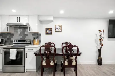 a kitchen with a table and chairs and a stove at New 2BR Suite, Walk to Dining, Near Downtown in Calgary