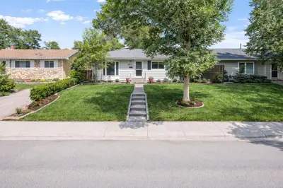 a house with a tree in the front yard at New 2BR Suite, Walk to Dining, Near Downtown in Calgary