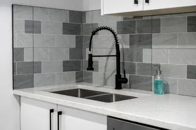 a kitchen counter with a sink in a kitchen at Bright 5-Bed Retreat Near the Zoo and Downtown in Calgary