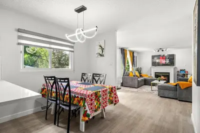 a dining room and living room with a table and chairs at Bright 5-Bed Retreat Near the Zoo and Downtown in Calgary