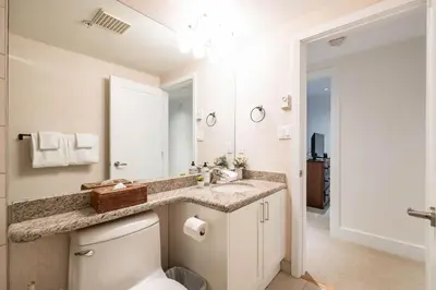 a bathroom with a toilet and a sink and a mirror at Woodrun Lodge 108 by Outpost Whistler in Whistler