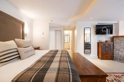a bedroom with a large bed and a brick wall at Woodrun Lodge 108 by Outpost Whistler in Whistler