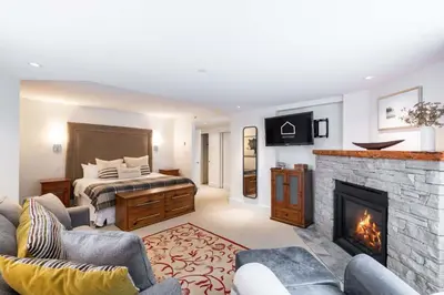 a living room with a bed and a fireplace at Woodrun Lodge 108 by Outpost Whistler in Whistler