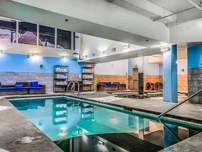 a swimming pool in a hotel room with a swimming pool at Exciting Rockies 1BR Escape with Hot Tub, Pool and BBQ in Canmore