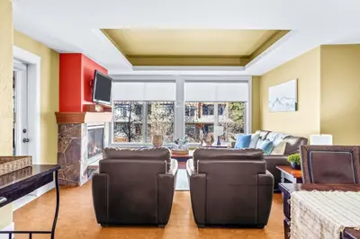 a living room with a couch and a fireplace at Exciting Rockies 1BR Escape with Hot Tub, Pool and BBQ in Canmore