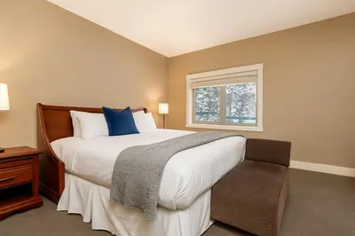 a bedroom with a large bed and a window at Mountain Bliss Spacious 2BR with Pool and Hot Tub in Canmore