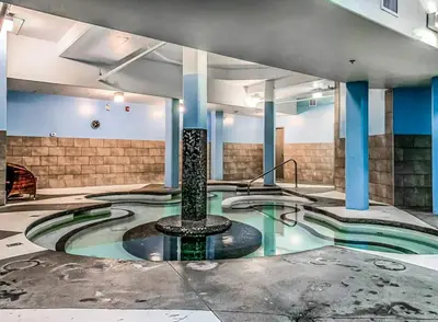 a swimming pool with a fountain in a building at Mountain View 2BR Condo with Hot Tub, Pool and Gym in Canmore