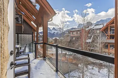 a balcony with a view of snow covered mountains at Mountain View 2BR Condo with Hot Tub, Pool and Gym in Canmore